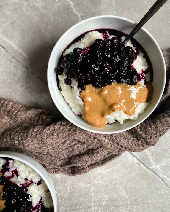 two bowls filled with food, one has blueberries