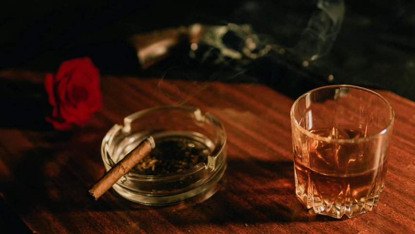 a small glass cup on a table next to a cigarette holder