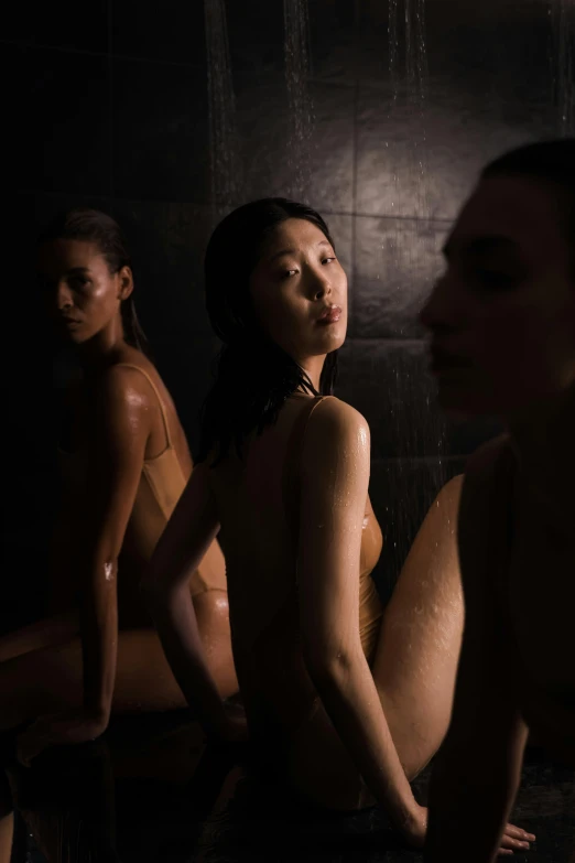 three women taking a shower in the dark
