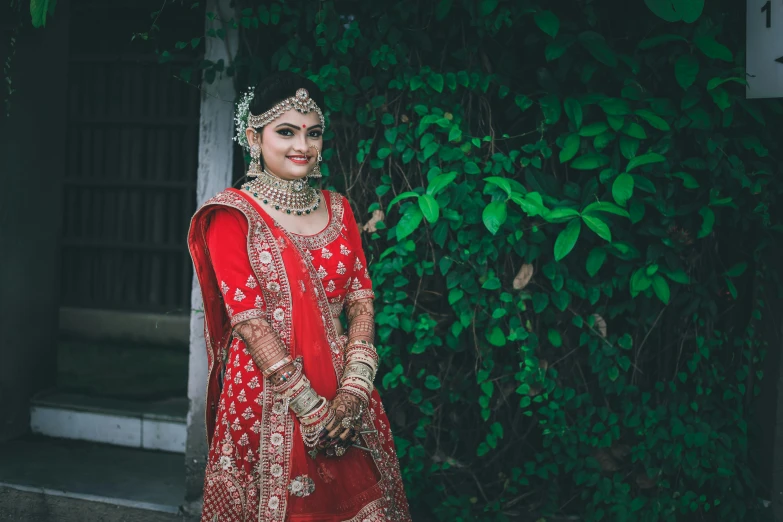 a beautiful indian bride in her bridal outfit poses for the camera