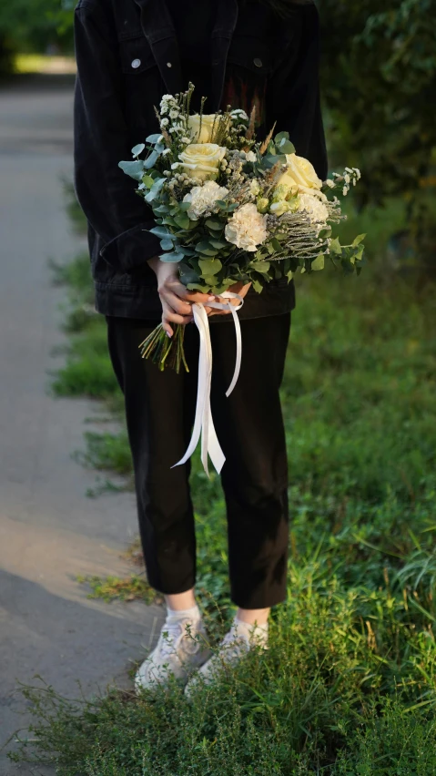 person holding an arrangement of flowers on the street