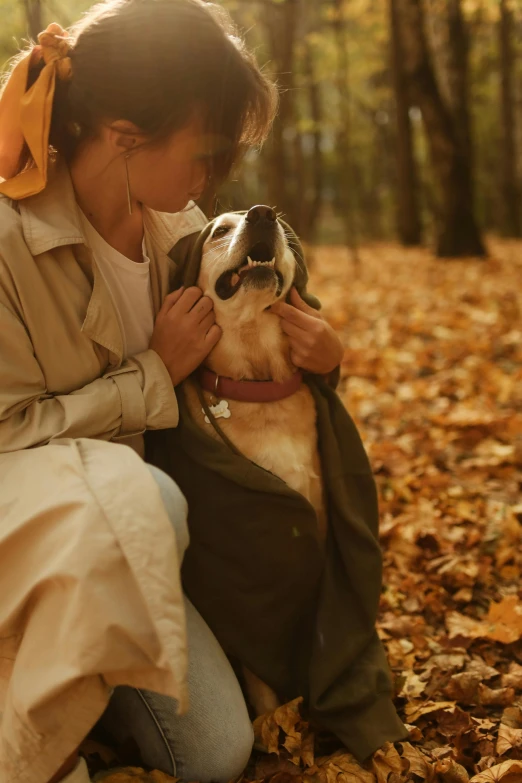 woman and dog posing for the camera in the leaves