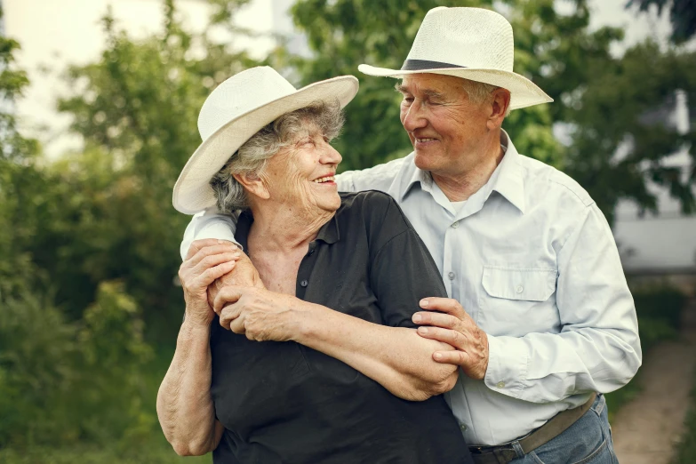 an older man and woman emcing in the woods