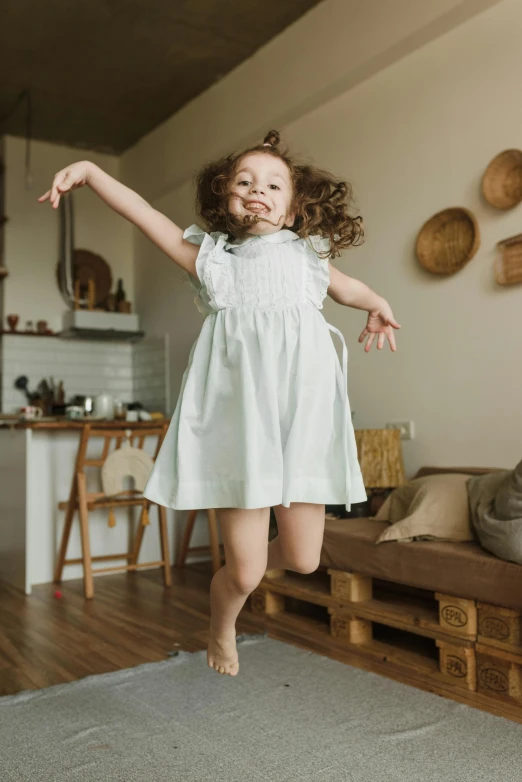 little girl jumping on rug in residential area