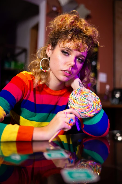 a woman in colorful shirt holding up a candy