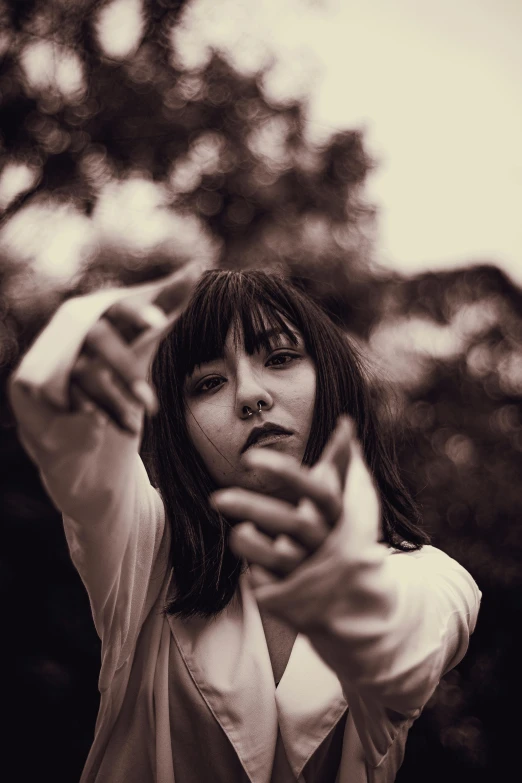 a woman aiming at the camera with a gun