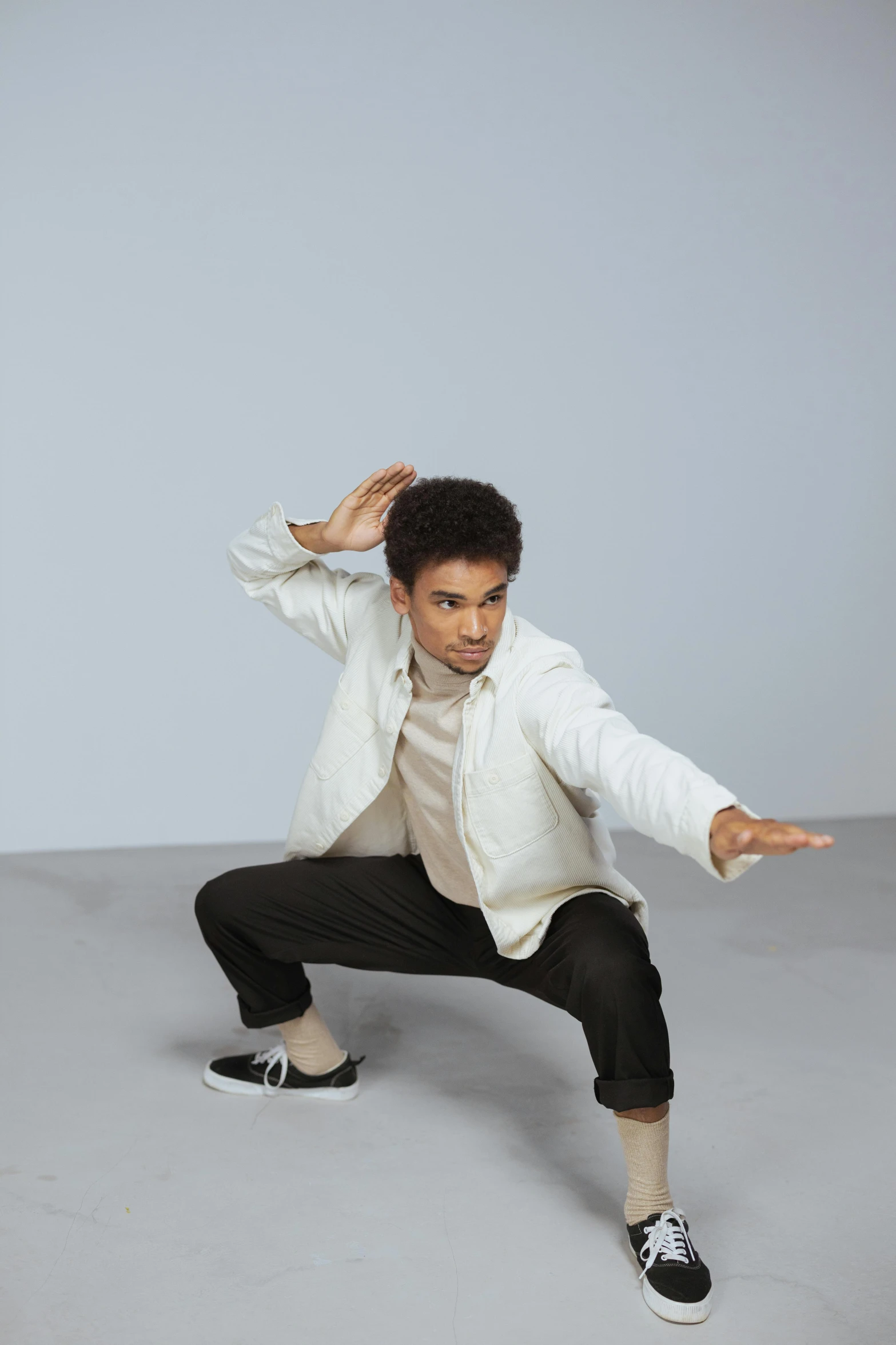 an indian man wearing a white jacket, shirt and black pants in the air