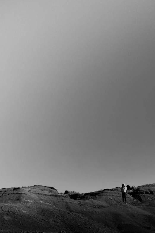 two people are standing on a hill alone