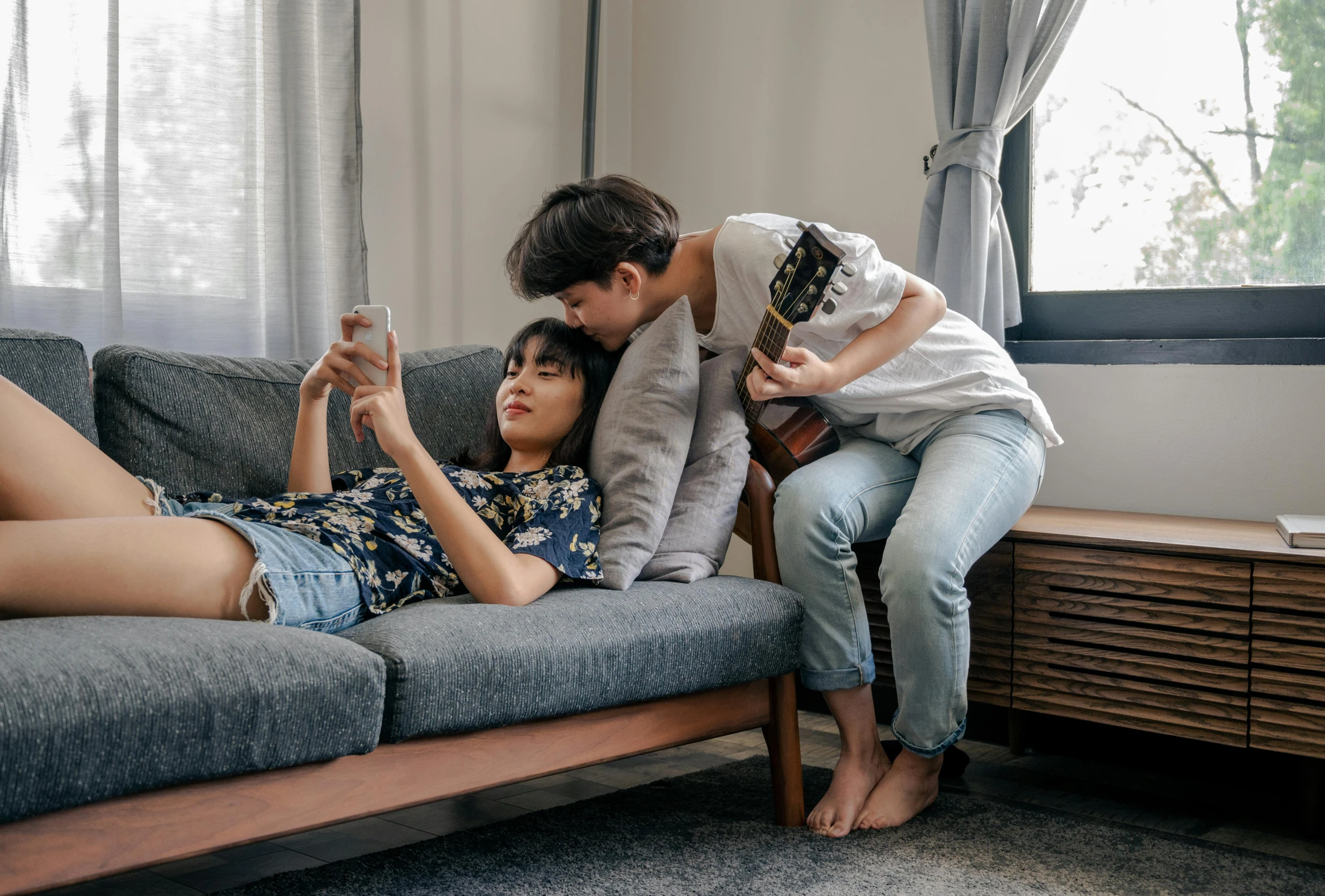 two people are lying on a couch together