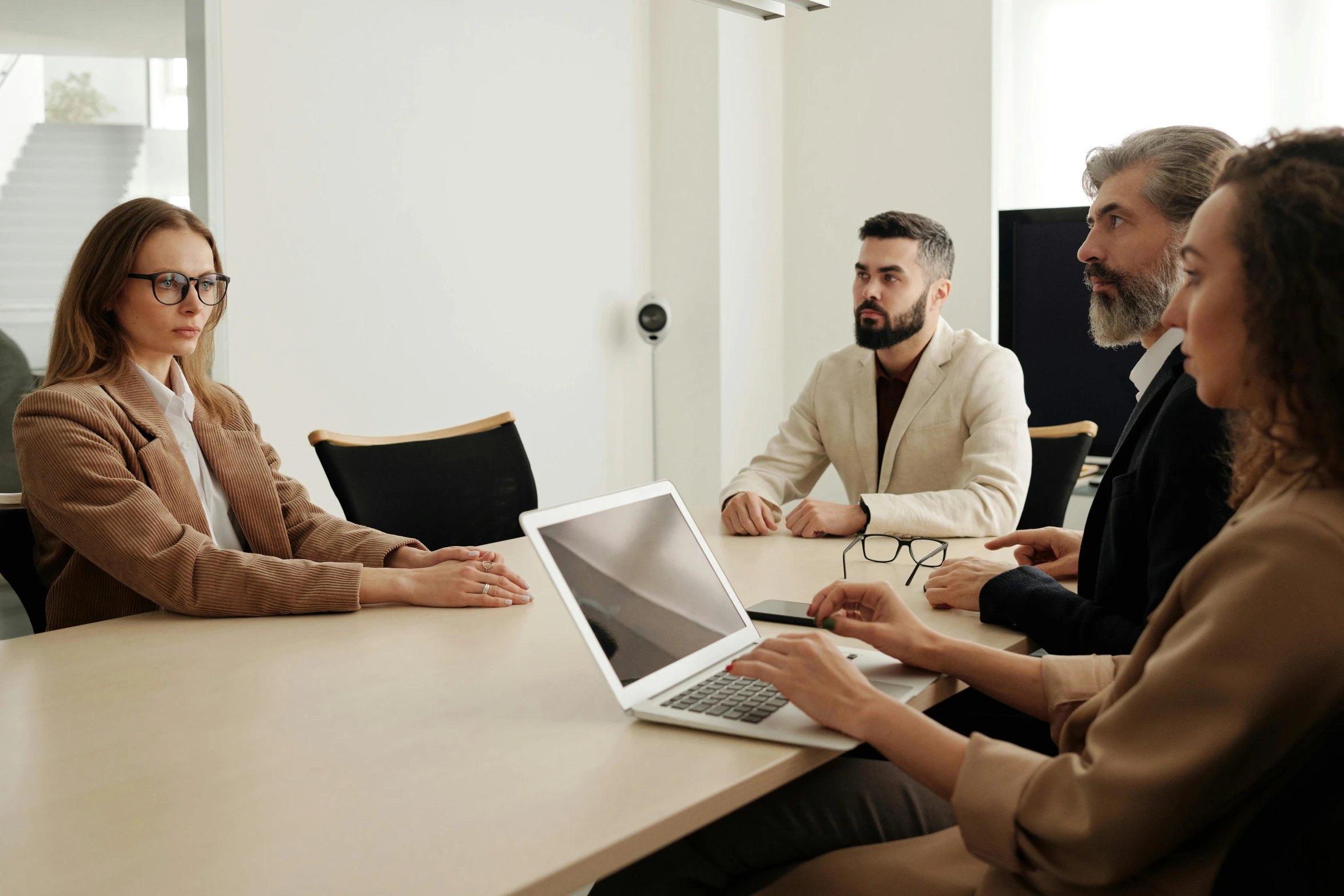 three people in an office meeting with laptop