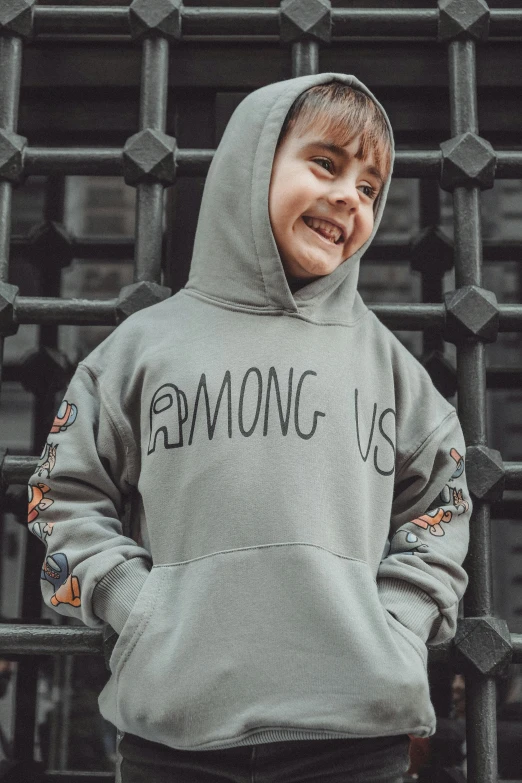 a child in grey and black hoodie smiling