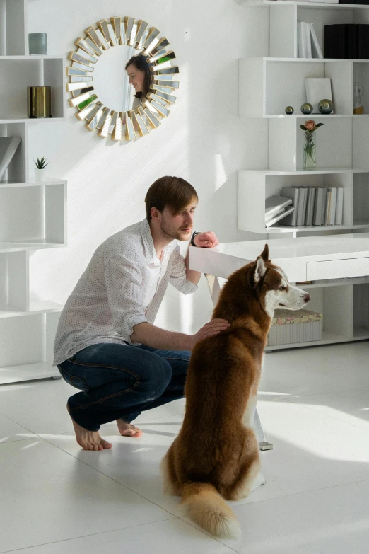 a man petting a dog while sitting on the ground