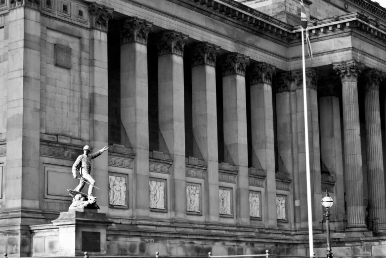 a statue of a man on a skateboard in front of a tall building