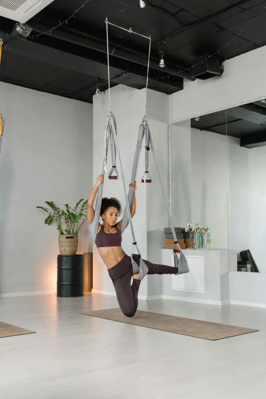 woman doing aerial yoga in an apartment exercise studio