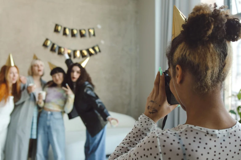 a group of girls are gathered around talking on their phones