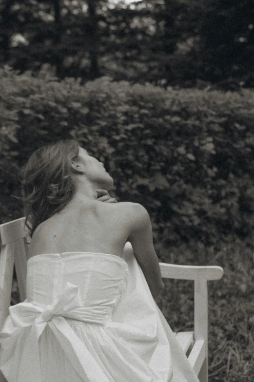 black and white pograph of a woman laying on a bench