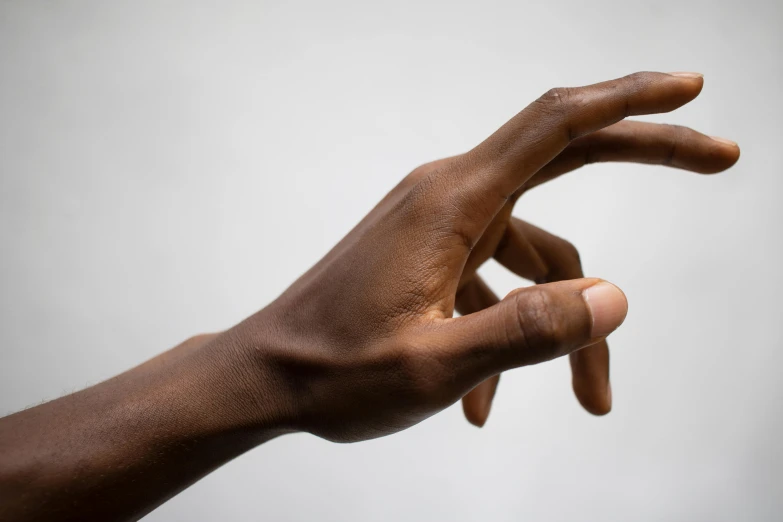 an african hand with a pointed index finger extended to the side