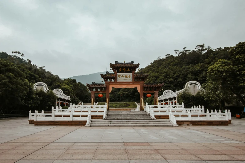 a white temple on a stone walkway near lots of trees