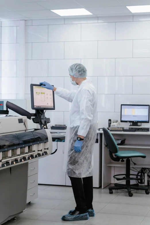 the person is wearing a white lab coat with gloves and rubber gloves