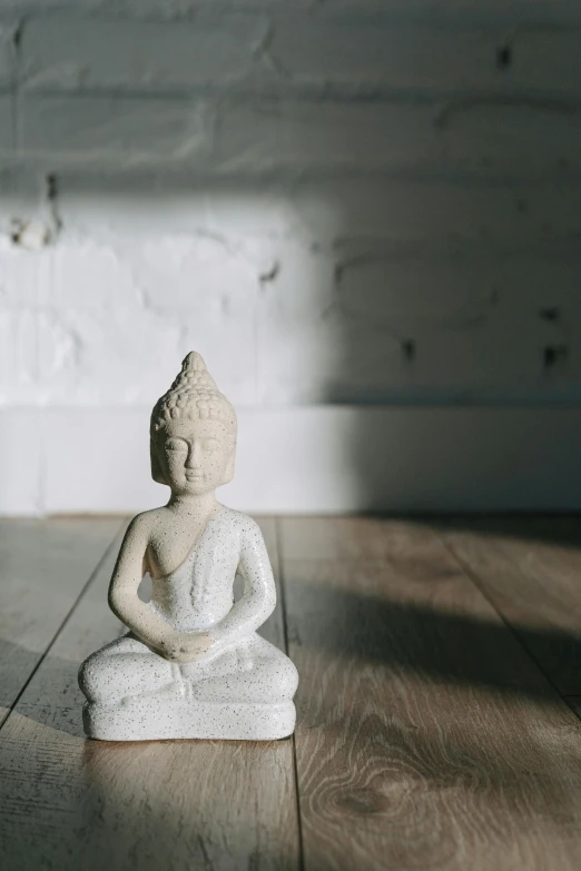 a small statue sits on a hardwood floor