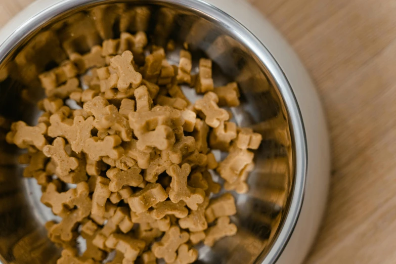 dog food being cooked in a bowl on a wooden table