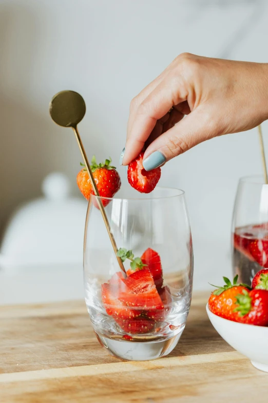 strawberries are being dipped in ice cream on a stick