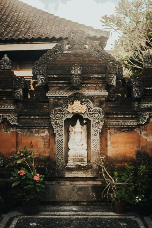 an indian temple with flowers and an old statue