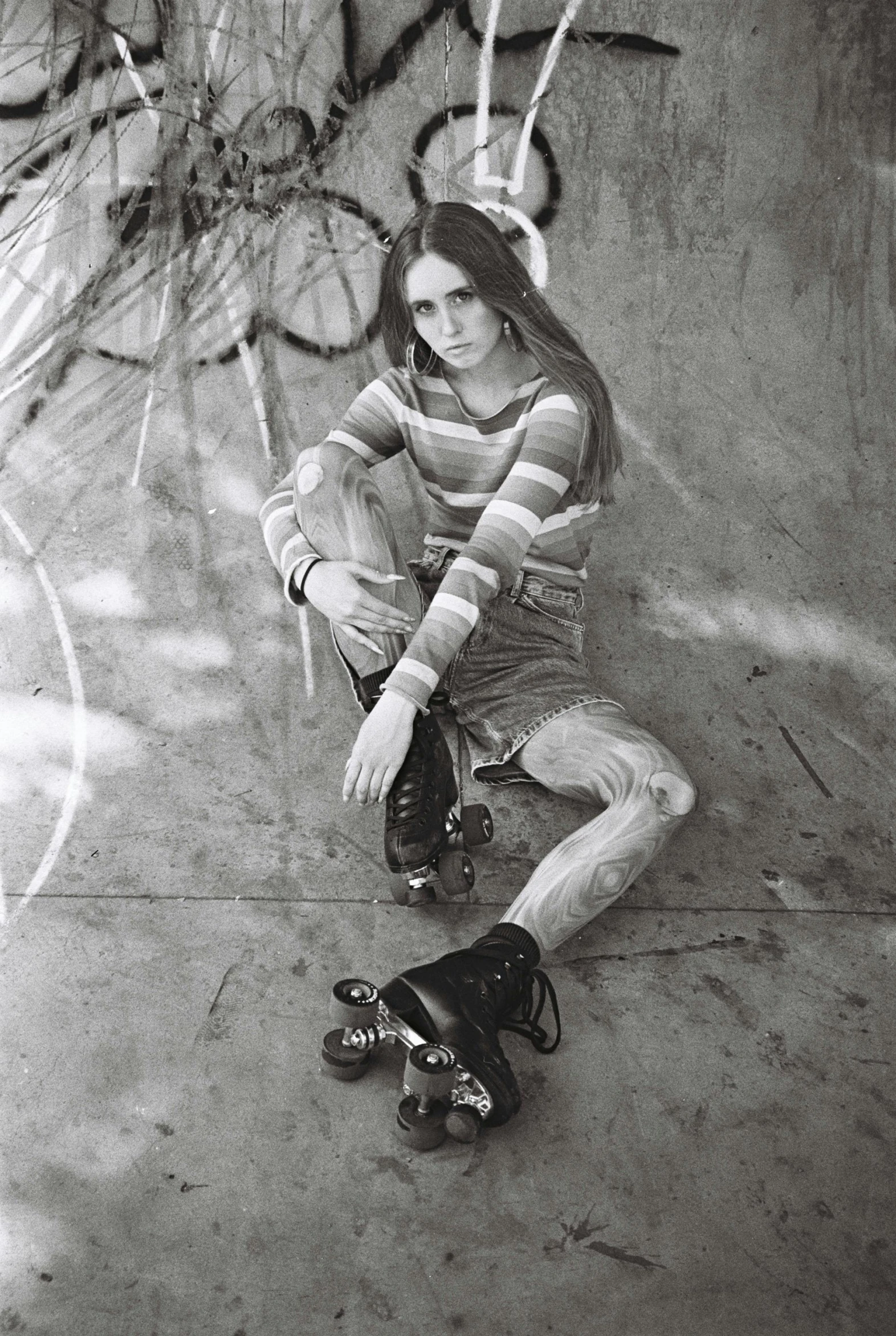 a girl wearing roller blades sits on a skateboard