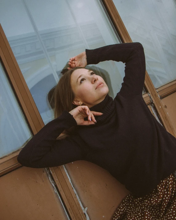 a woman leaning on the side of a building