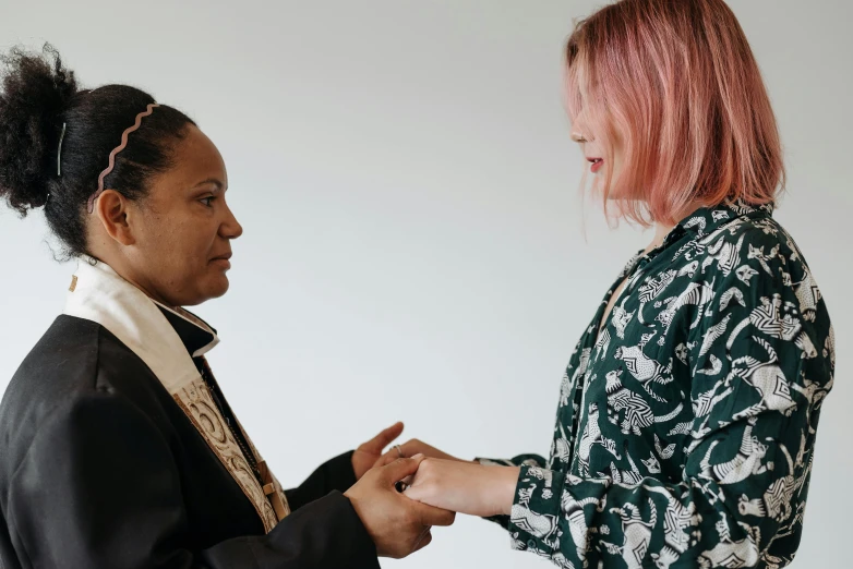 two women are sharing a conversation over a white background