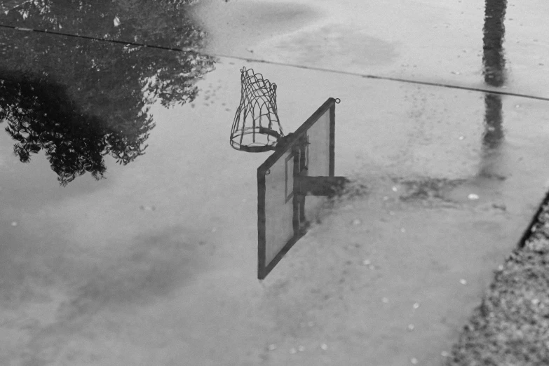 an empty basketball hoop reflecting in the water