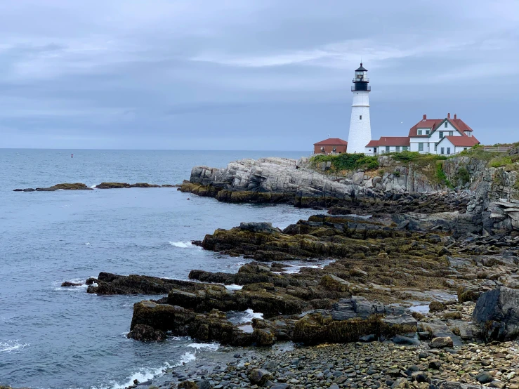 a light house is in the distance next to the ocean