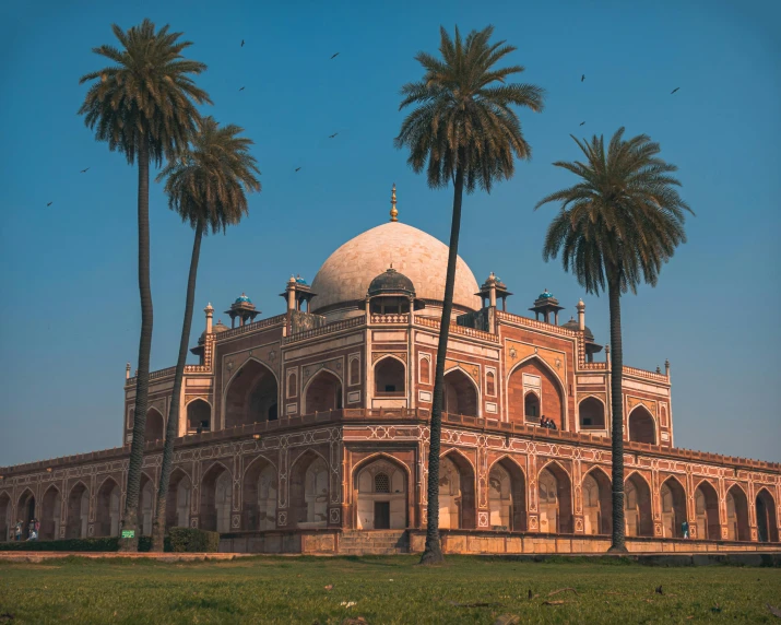 an old building with palm trees in front