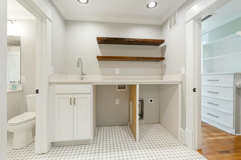 a bathroom with all white cabinets and wood trim