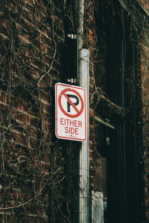 a street sign on a metal pole against a brick building