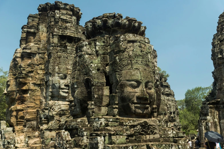 the large statues of two heads are carved into a stone wall