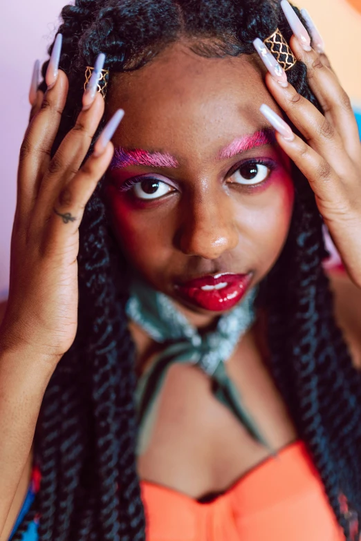 a woman with bright makeup holding her hands in her hair