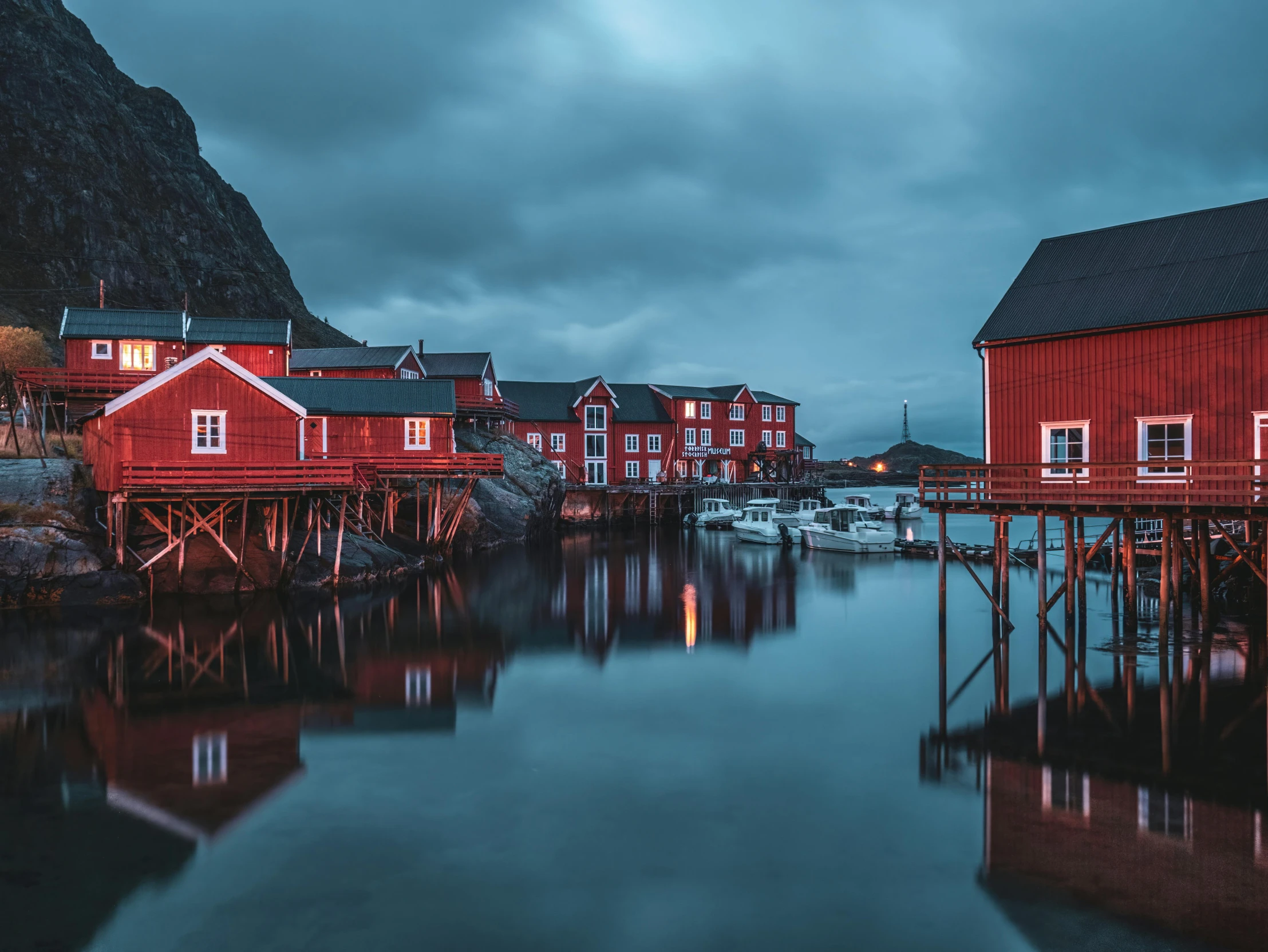 a wooden dock with some houses on the side and water underneath