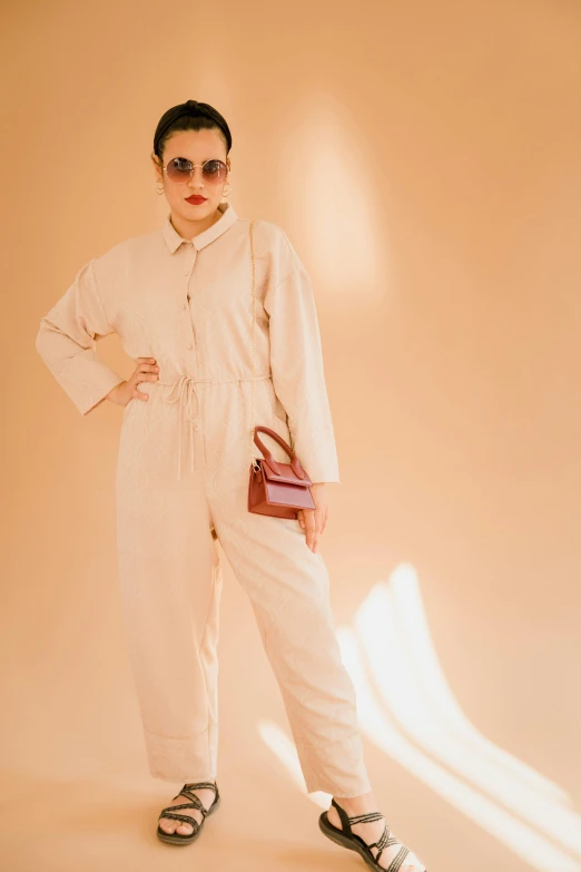 a person wearing a white jumpsuit and holding a bag