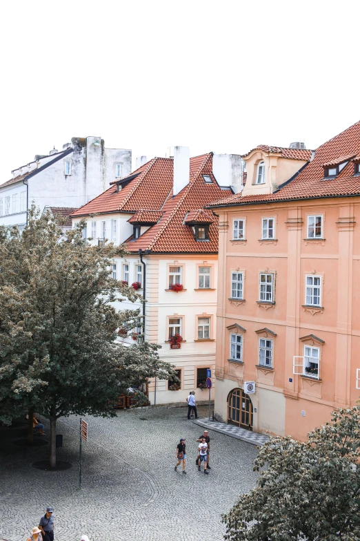 people walk near tall buildings on an old european street