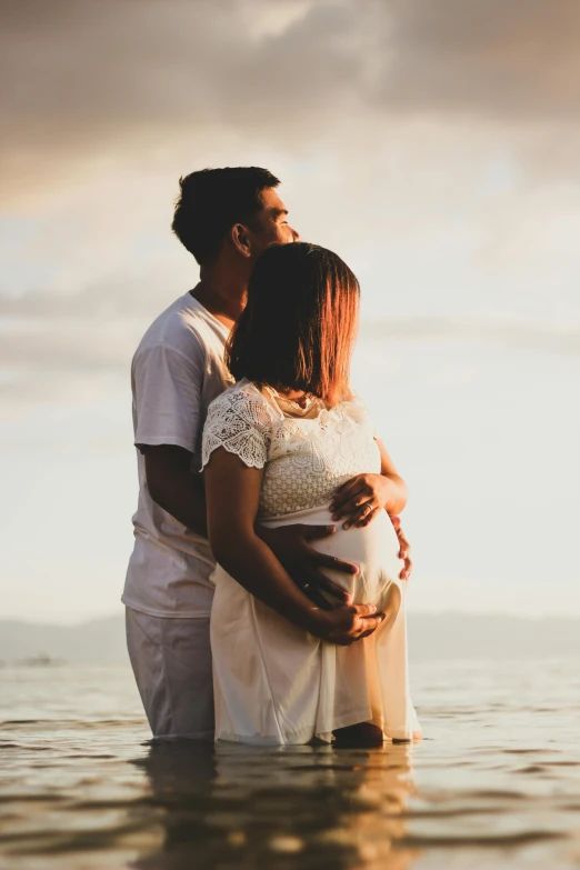 man and woman hugging while standing in water