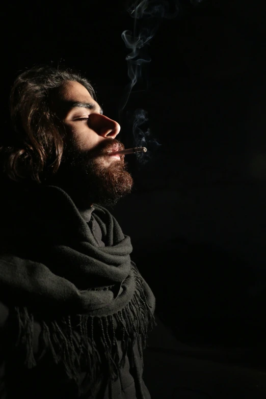 a man is shown smoking and wearing a shawl