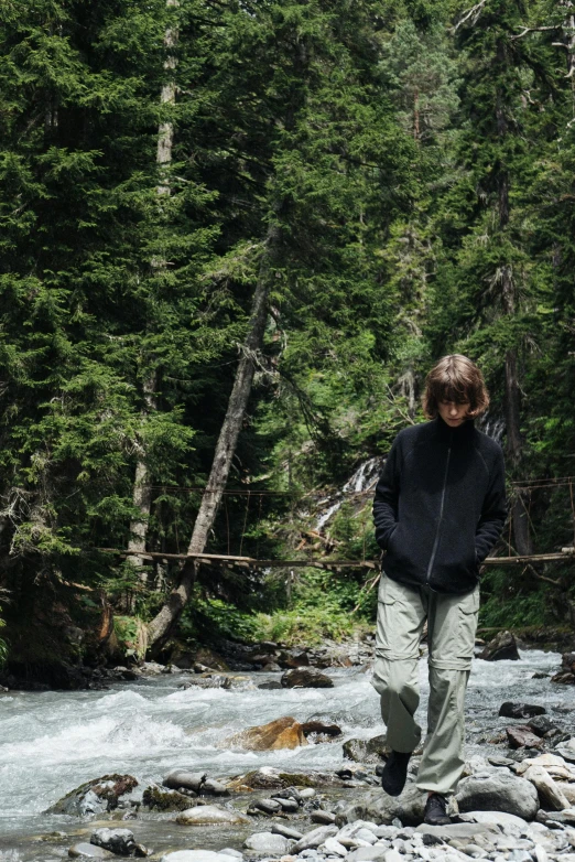 the person in black jacket is walking in the water