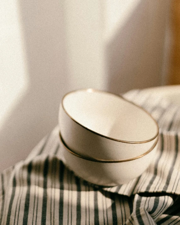 white dishes and white stripes are placed on the striped linen