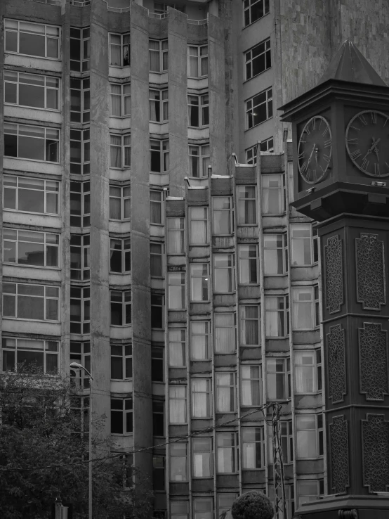 an old clock sitting in front of two very tall buildings