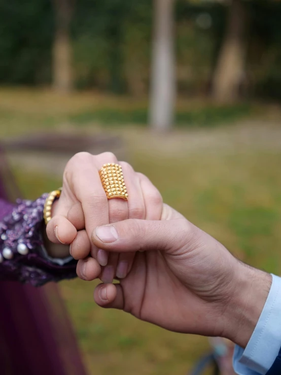 two people hold each other's hand outside