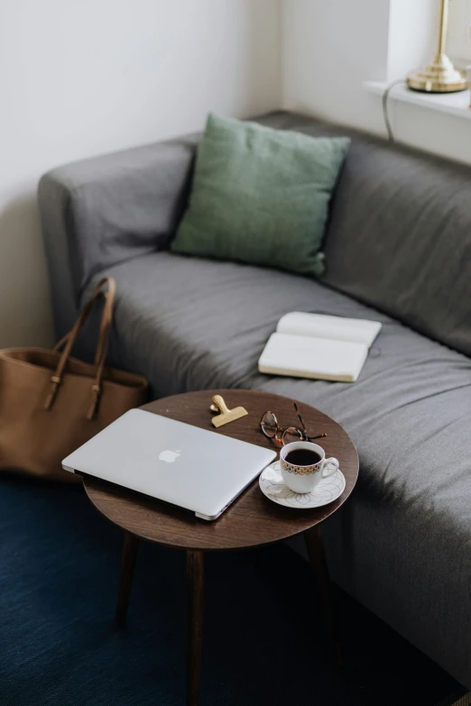 a laptop and a purse sit on top of the coffee table