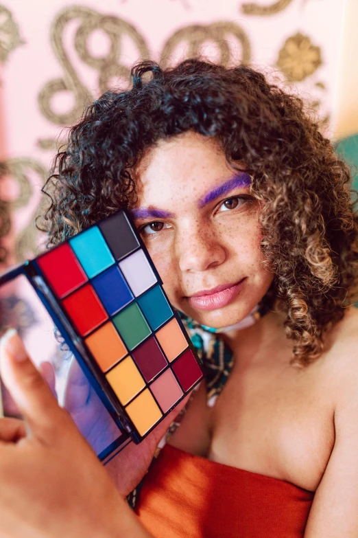 a woman holds a square colorful palette while holding it