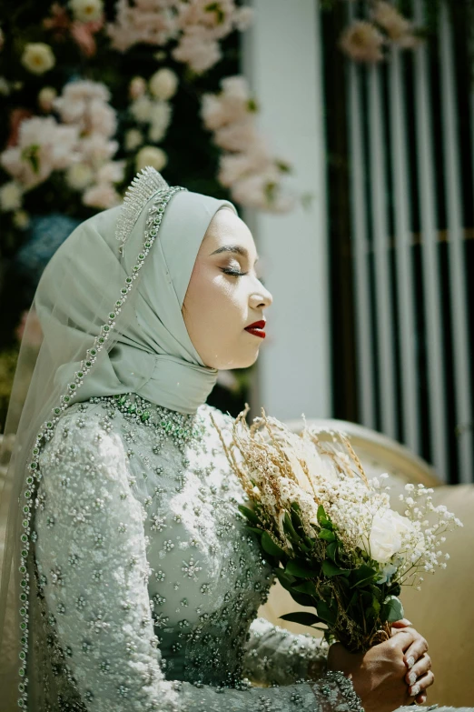 an arabic bride sits holding flowers in her hands