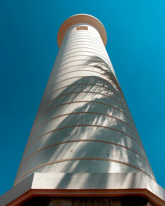 a large white tower with a red roof against the blue sky